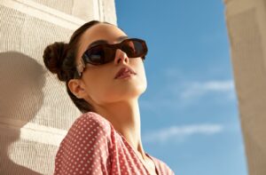 A stylish woman wearing sunglasses to protect her dry eyes from the outdoors.