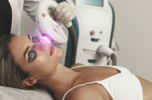 A patient lying on a table with eye coverings on while receiving IPL Therapy.