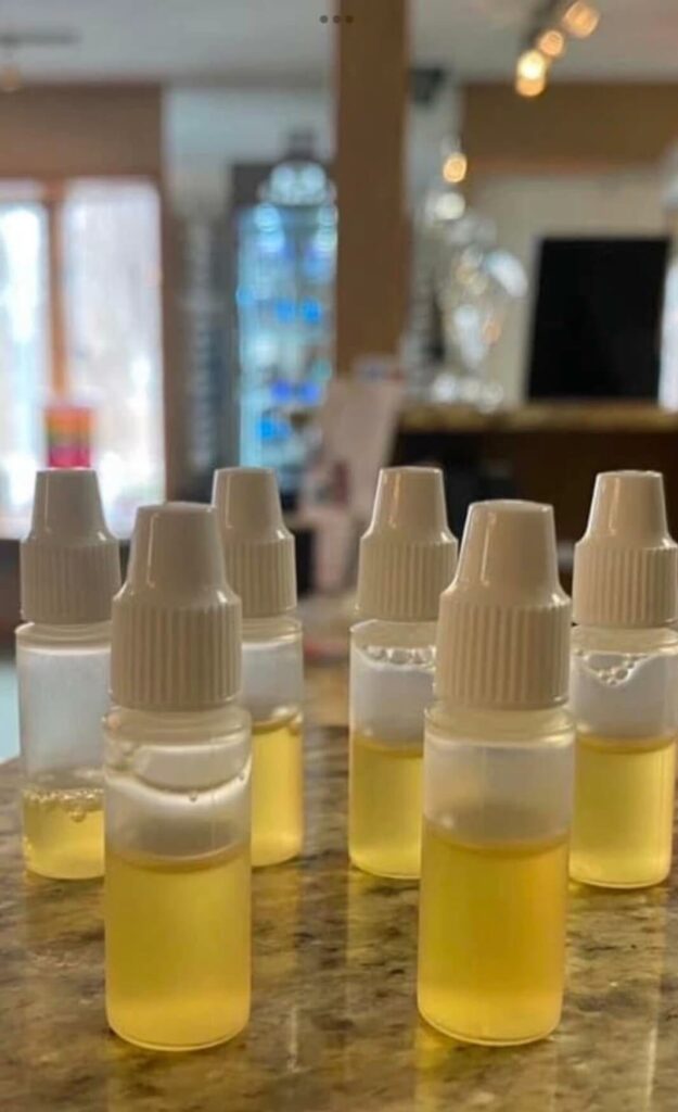 Multiple small dropper bottles containing yellow-tinted PRP (Platelet-Rich Plasma) eye drops on a counter.